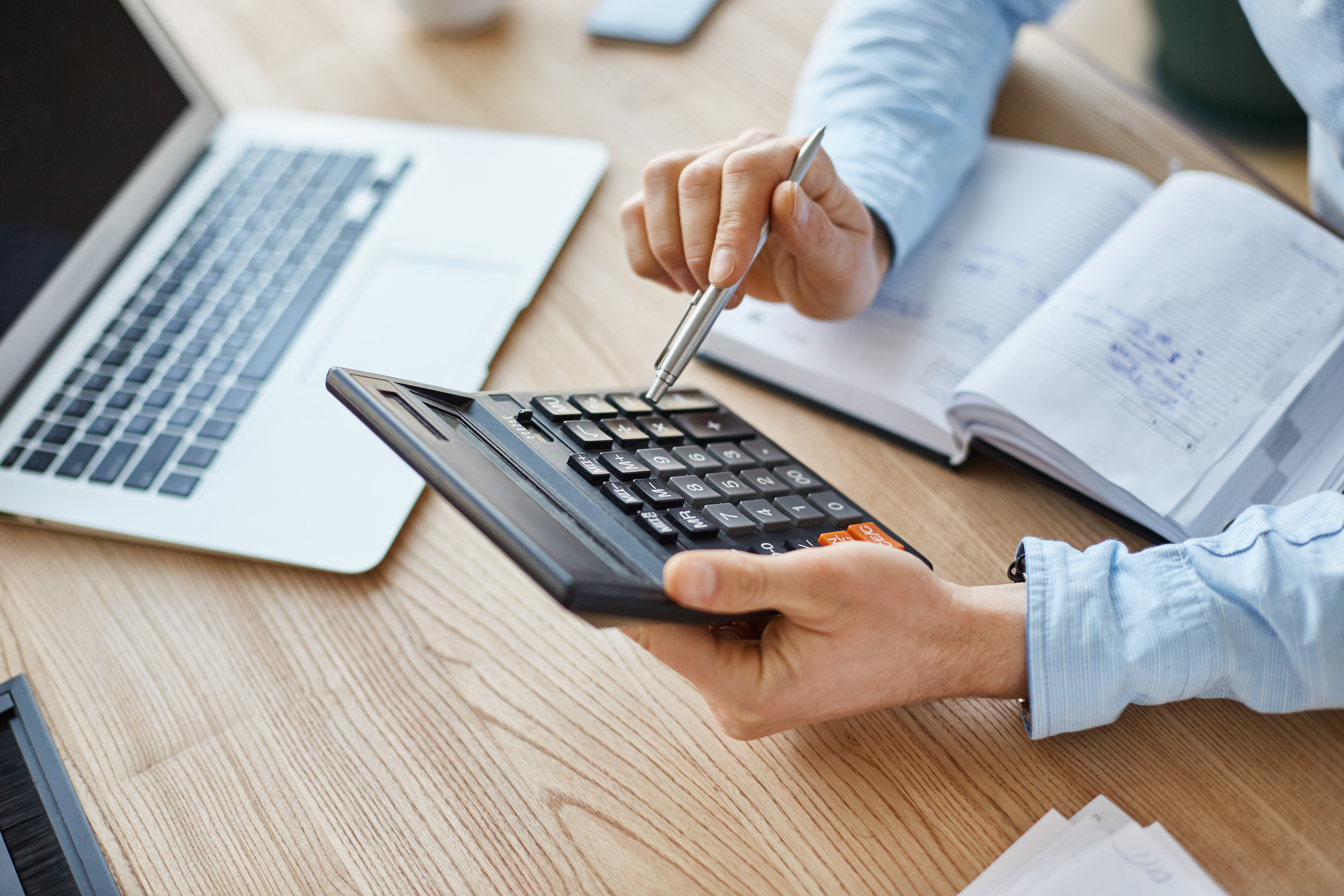 vista-recortada-gerente-financeiro-profissional-serio-segurando-calculadora-nas-maos-verificando-os-lucros-mes-da-empresa-1.jpg